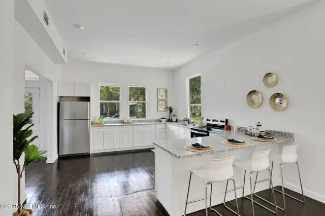 a kitchen with a sink appliances and wooden floor