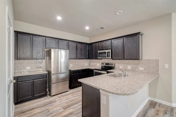 a kitchen with stainless steel appliances granite countertop a sink stove and refrigerator