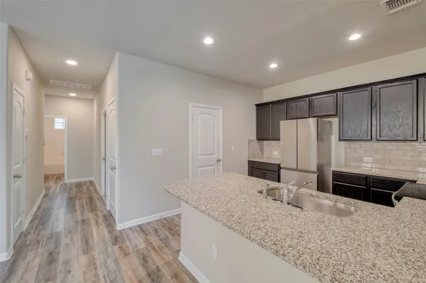 a kitchen with stainless steel appliances granite countertop a refrigerator and a sink