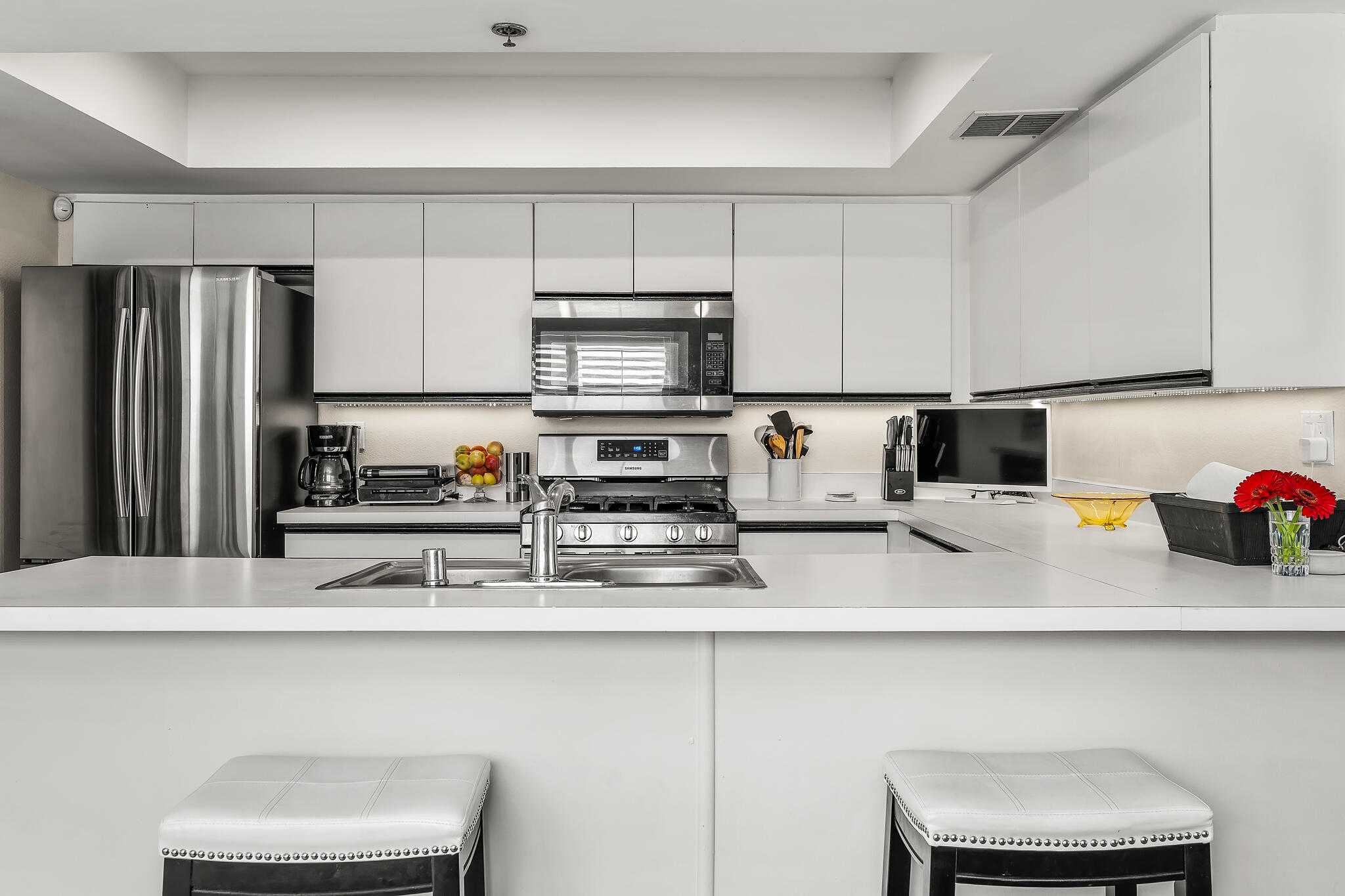 200 East Racquet Club Road, Unit 54 Palm Springs, CA 92262 - Photo 11 of 29 a kitchen with stainless steel appliances a sink a stove a microwave a refrigerator and cabinets