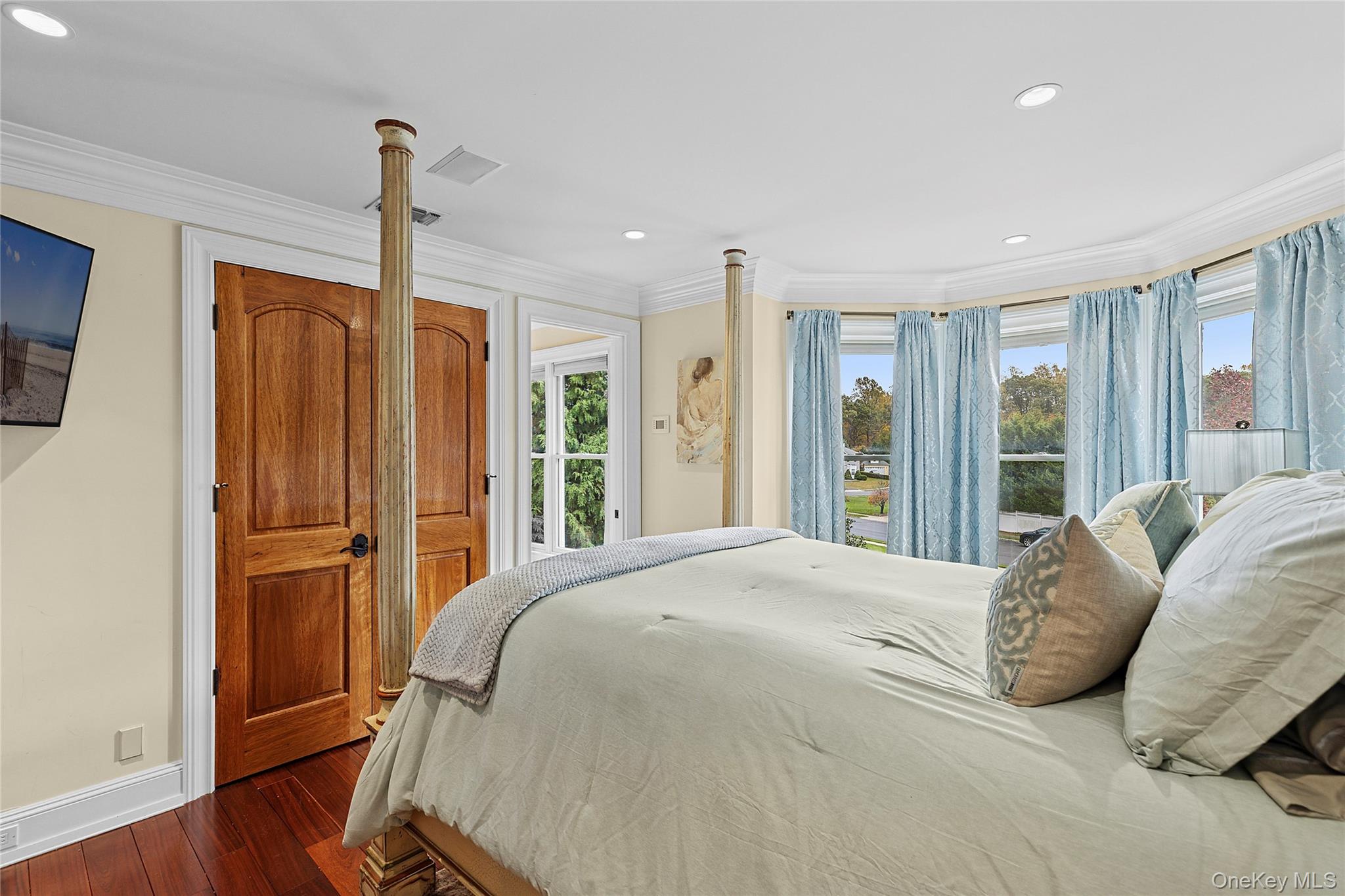 5 Schoolhouse Court Oyster Bay, NY 11771 - Photo 20 of 33 a bed sitting in a spacious bedroom next to a window