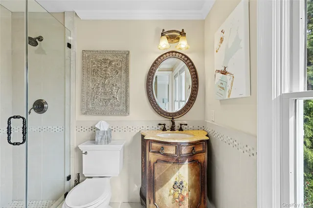 a bathroom with a toilet sink vanity and mirror