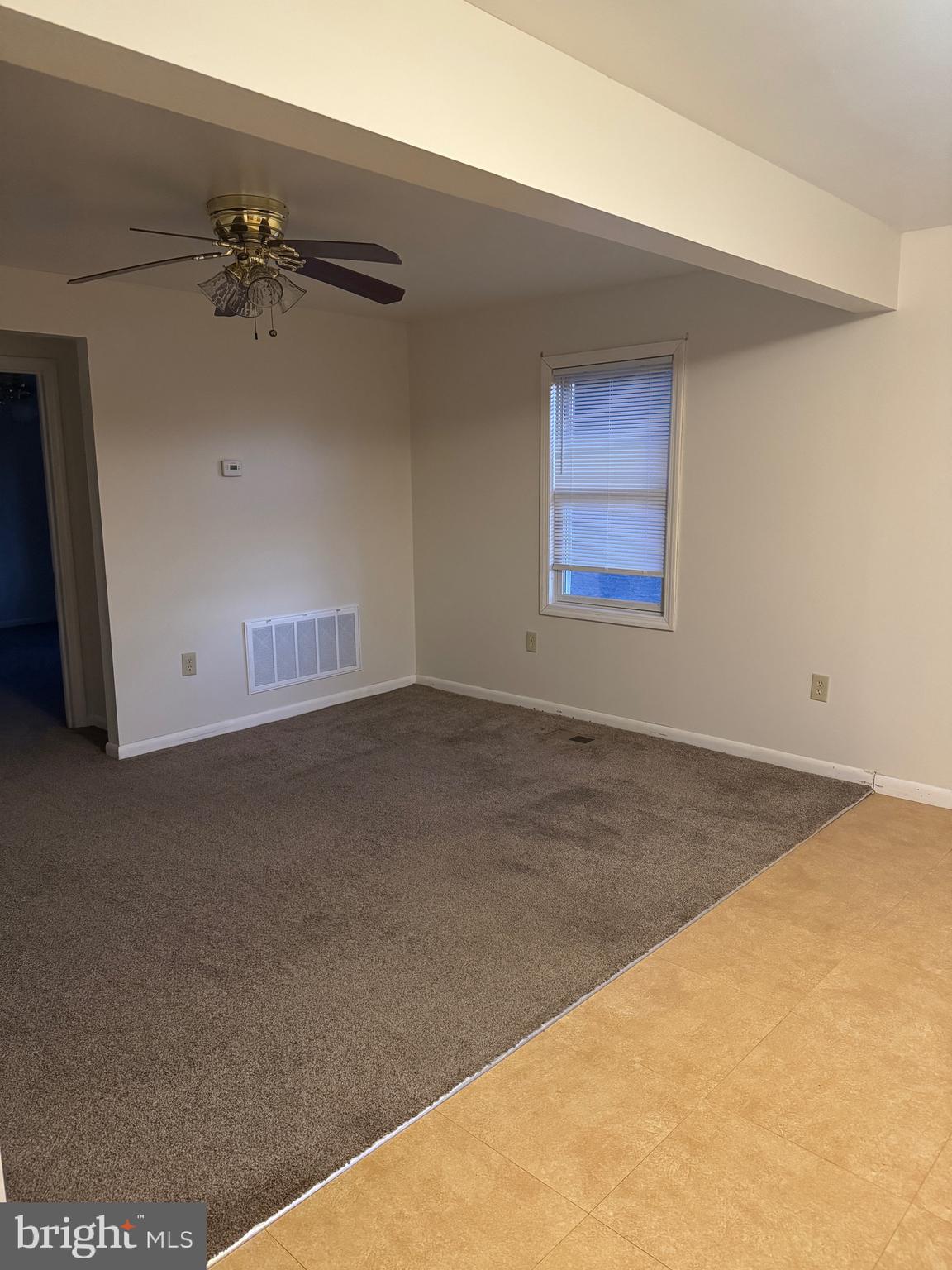 4594 Post Road Vineland, NJ 08360 - Photo 3 of 7 an empty room with a ceiling fan and window