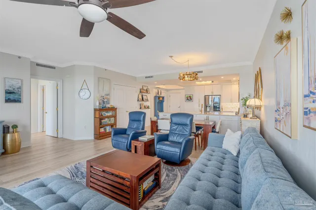 a bedroom with a large bed and a chandelier fan