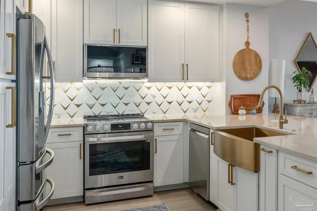 a kitchen with stainless steel appliances granite countertop a refrigerator and a sink
