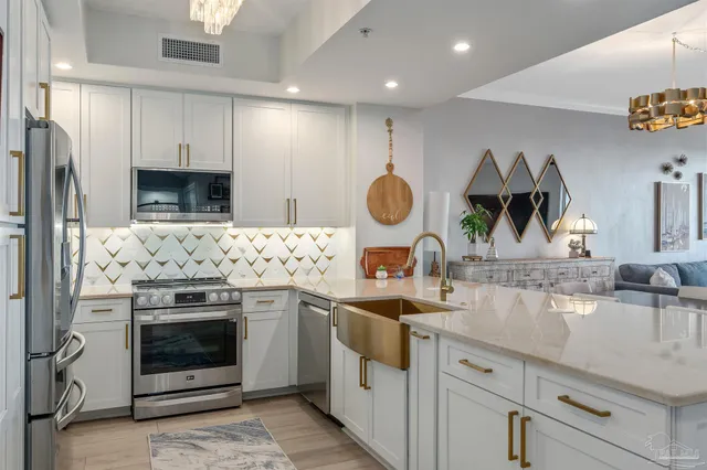 a kitchen with stainless steel appliances granite countertop a sink and a refrigerator