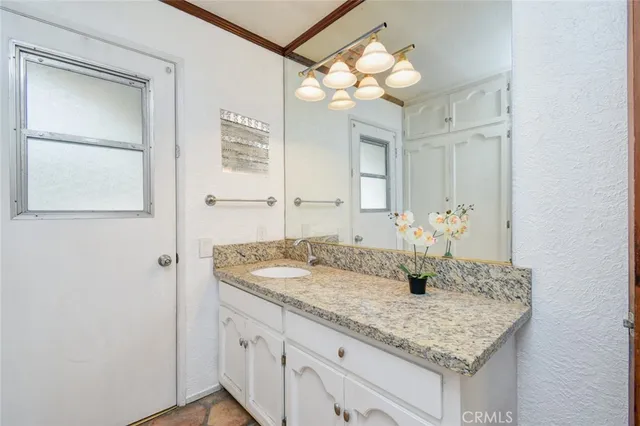 a bathroom with a granite countertop sink and a mirror
