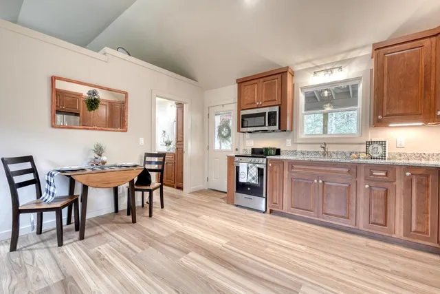 a kitchen with stainless steel appliances granite countertop a refrigerator a stove a sink and a microwave