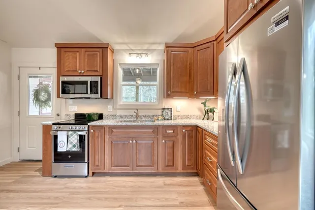 a kitchen with stainless steel appliances granite countertop a refrigerator stove microwave and sink