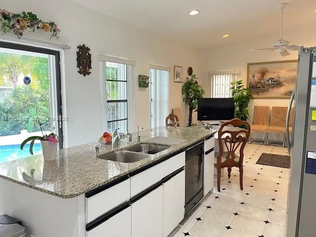 a kitchen with stainless steel appliances granite countertop a refrigerator sink and stove