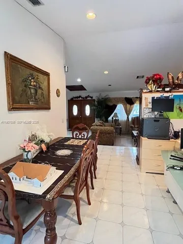 a living room with furniture and a refrigerator