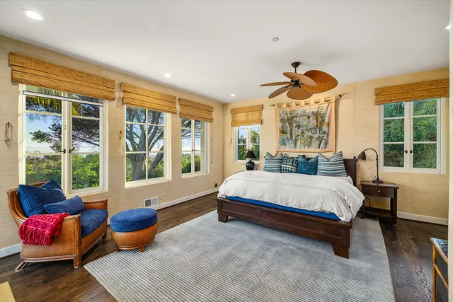 a spacious bedroom with a bed and large windows