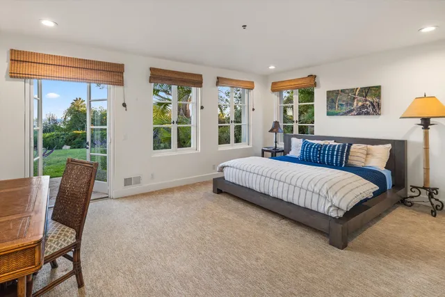 a spacious bedroom with a bed and wooden floor