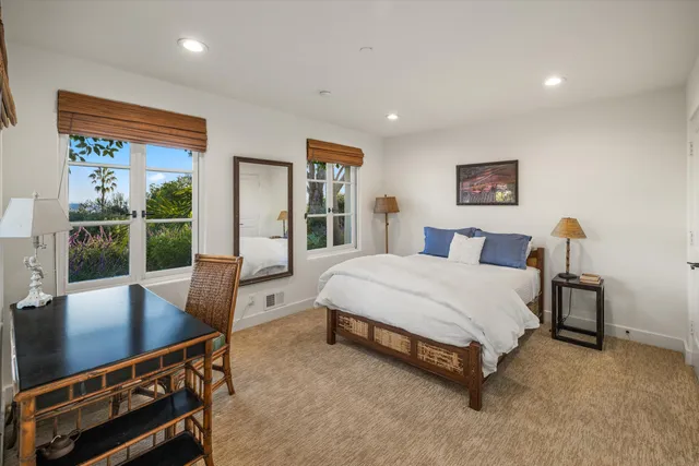 a spacious bedroom with a bed a table and chair