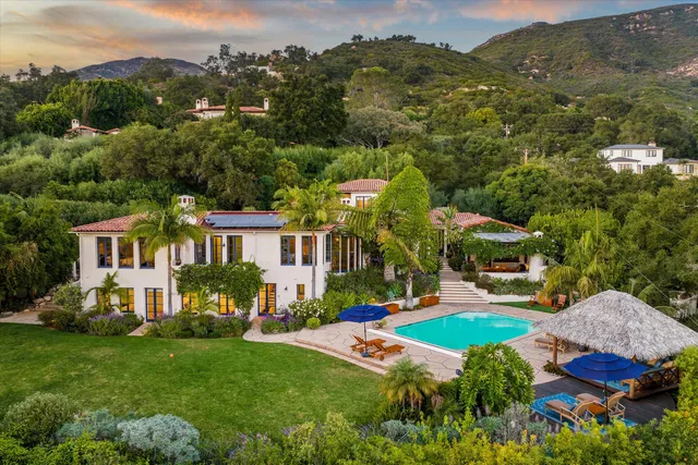 a view of a front of residential houses with yard and green space