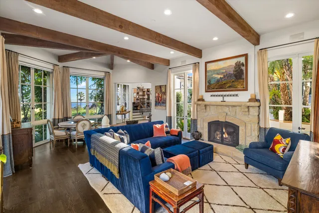 a living room with furniture fireplace and a large window