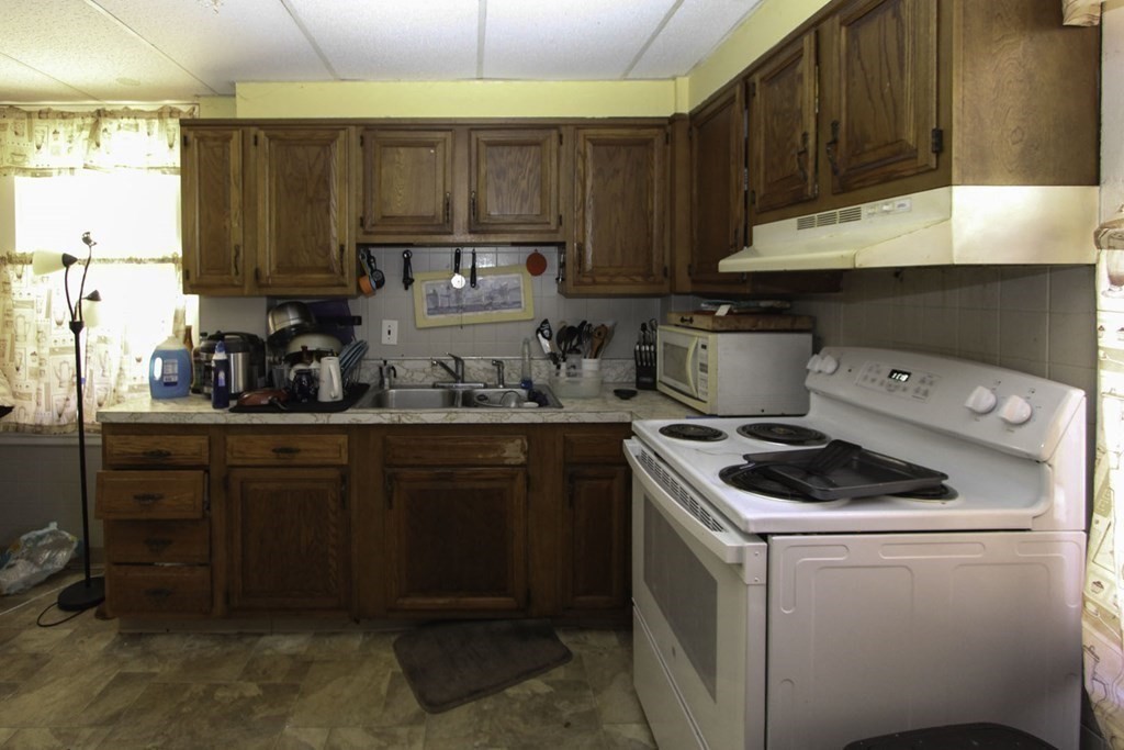 68 Bemis Road Fitchburg, MA 01420 - Photo 11 of 21 a kitchen with sink a stove and cabinets