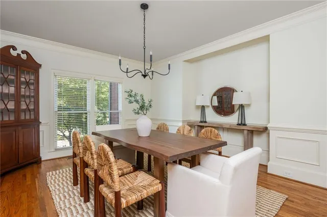 a view of a dining room with furniture a potted plant and windows