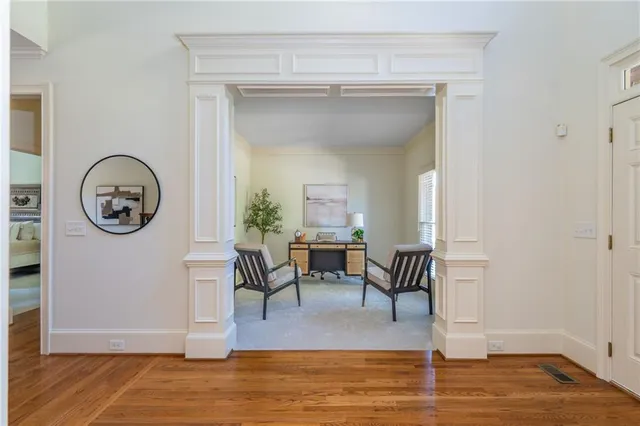 a dining room with wooden floor a chandelier a wooden table and chairs