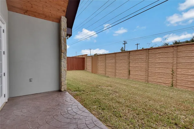 a view of backyard with large trees and wooden fence