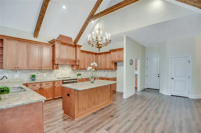 a kitchen with a sink a stove cabinets and wooden floor