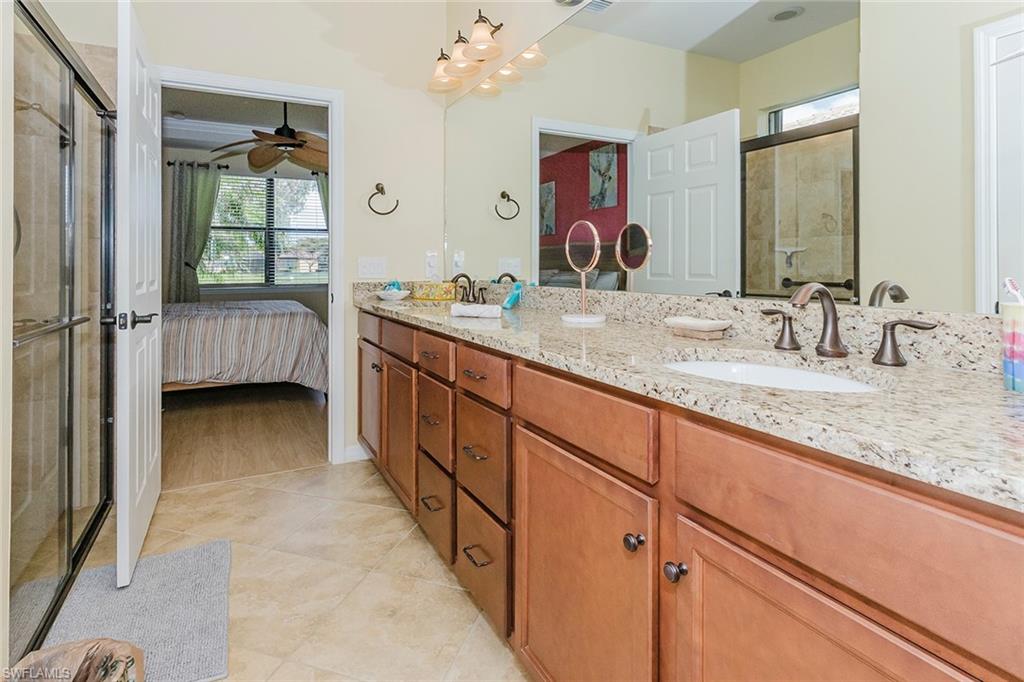 6441 Liberty Street Ave Maria, FL 34142 - Photo 28 of 48 a bathroom with a granite countertop sink a mirror and a bathtub