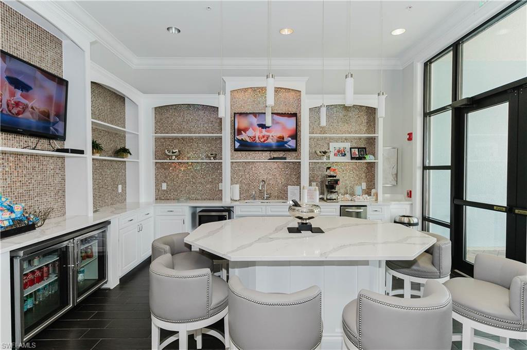 6441 Liberty Street Ave Maria, FL 34142 - Photo 36 of 48 a kitchen with a sink stove and chairs