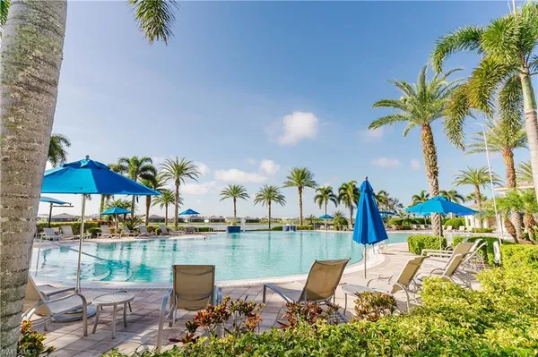a dining room with furniture water view and a floor to ceiling window