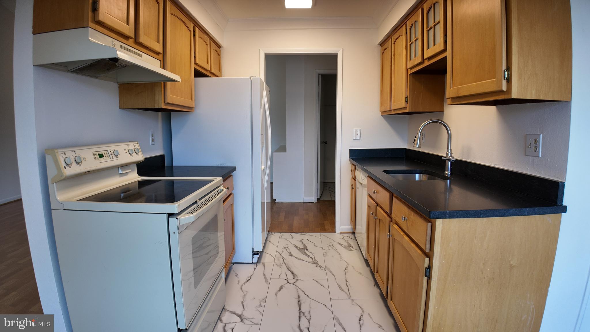15311 Beaverbrook Court, Unit 903B Silver Spring, MD 20906 - Photo 14 of 36 a kitchen with a sink a stove and a microwave