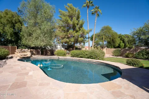 a view of a swimming pool with a yard from a seating space