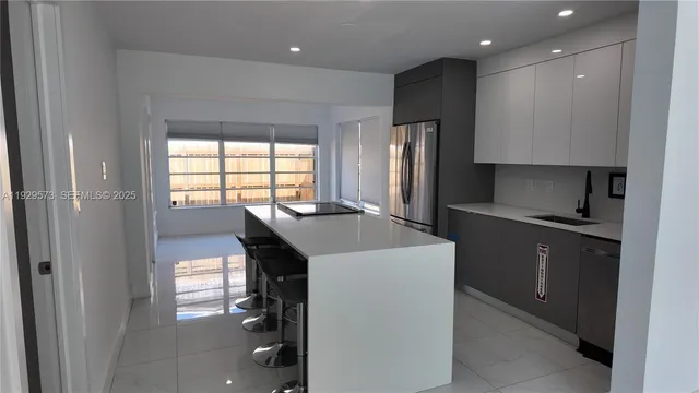 a kitchen with a sink a refrigerator and wooden floor