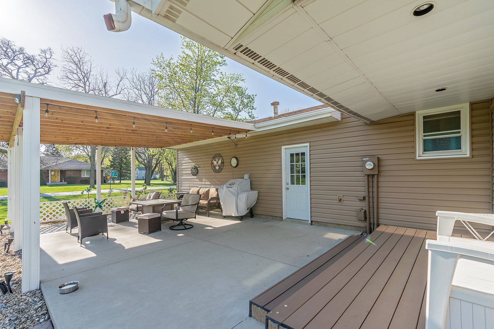 902 Warren Street Chenoa, IL 61726 - Photo 12 of 36 a view of a patio with table and chairs potted plants with wooden floor and fence