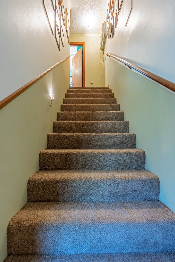 902 Warren Street Chenoa, IL 61726 - Photo 28 of 36 a living room with white walls and stairs