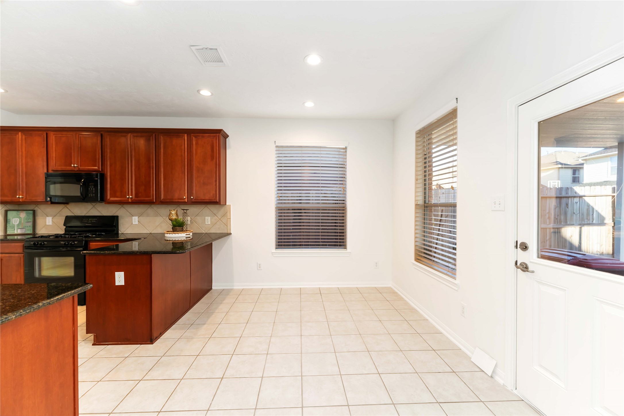 7226 VORGEN Court Spring, TX 77379 - Photo 18 of 43 a kitchen with stainless steel appliances granite countertop a stove a sink and a microwave