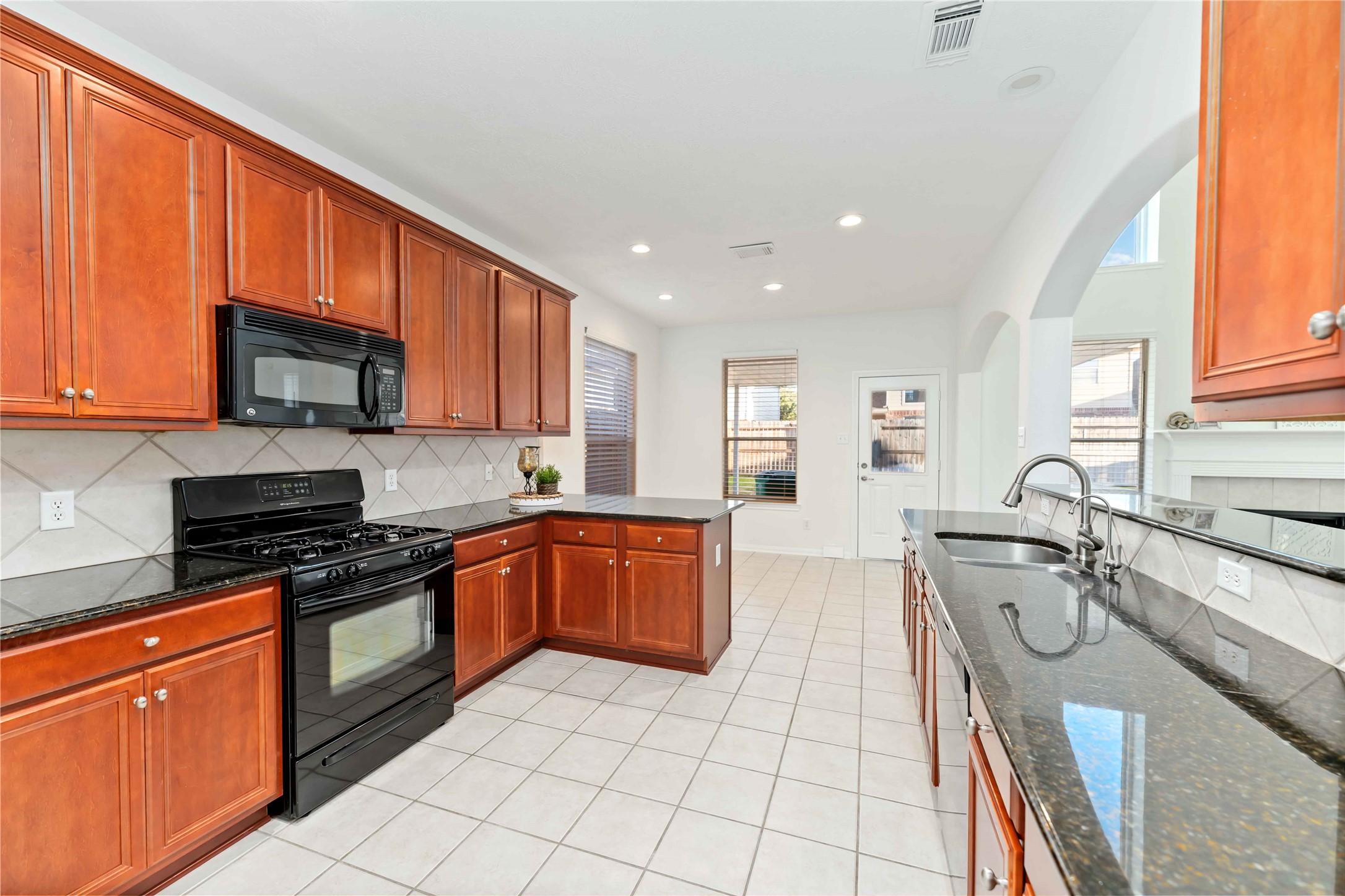 7226 VORGEN Court Spring, TX 77379 - Photo 19 of 43 a kitchen with stainless steel appliances granite countertop wooden cabinets a stove top oven a sink and dishwasher