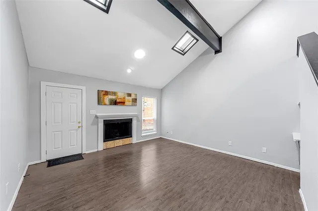 an empty room with windows and fireplace