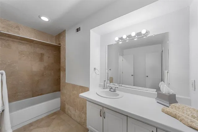 a bathroom with a sink double vanity granite tub shower and a mirror