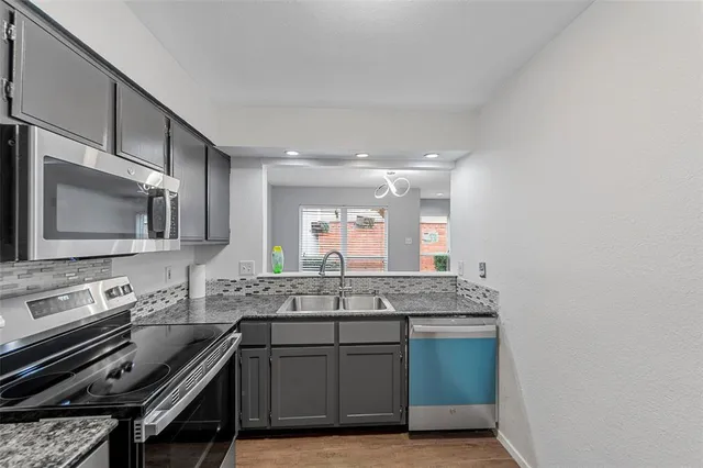 a kitchen with a sink stove and microwave