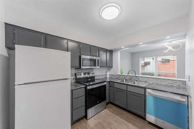 a kitchen with refrigerator a sink and wooden cabinets