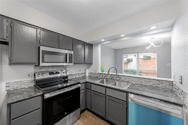 a kitchen with a sink stove and microwave