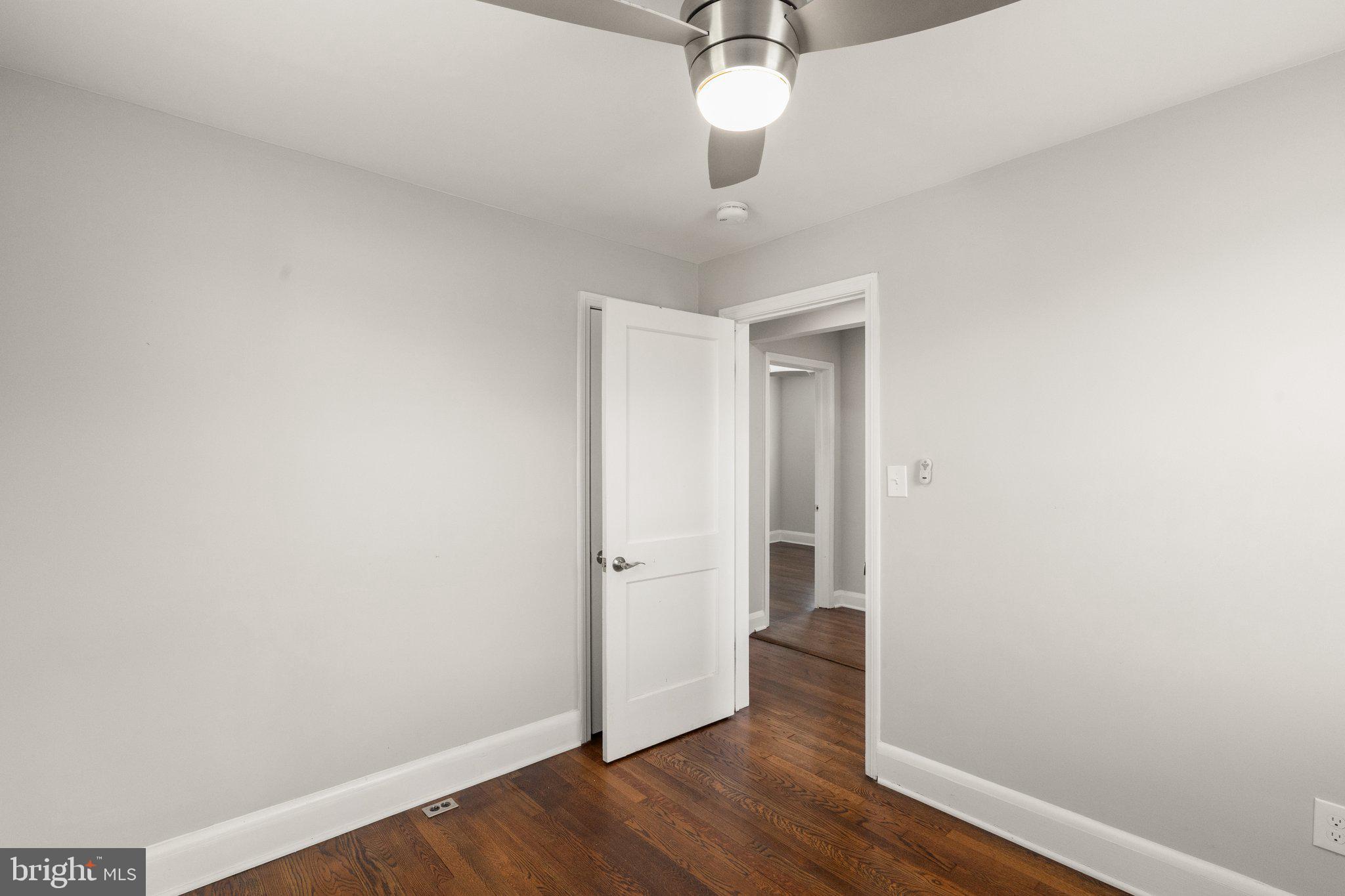 7512 Brightside Avenue Baltimore, MD 21237 - Photo 13 of 32 an empty room with wooden floor and a ceiling fan