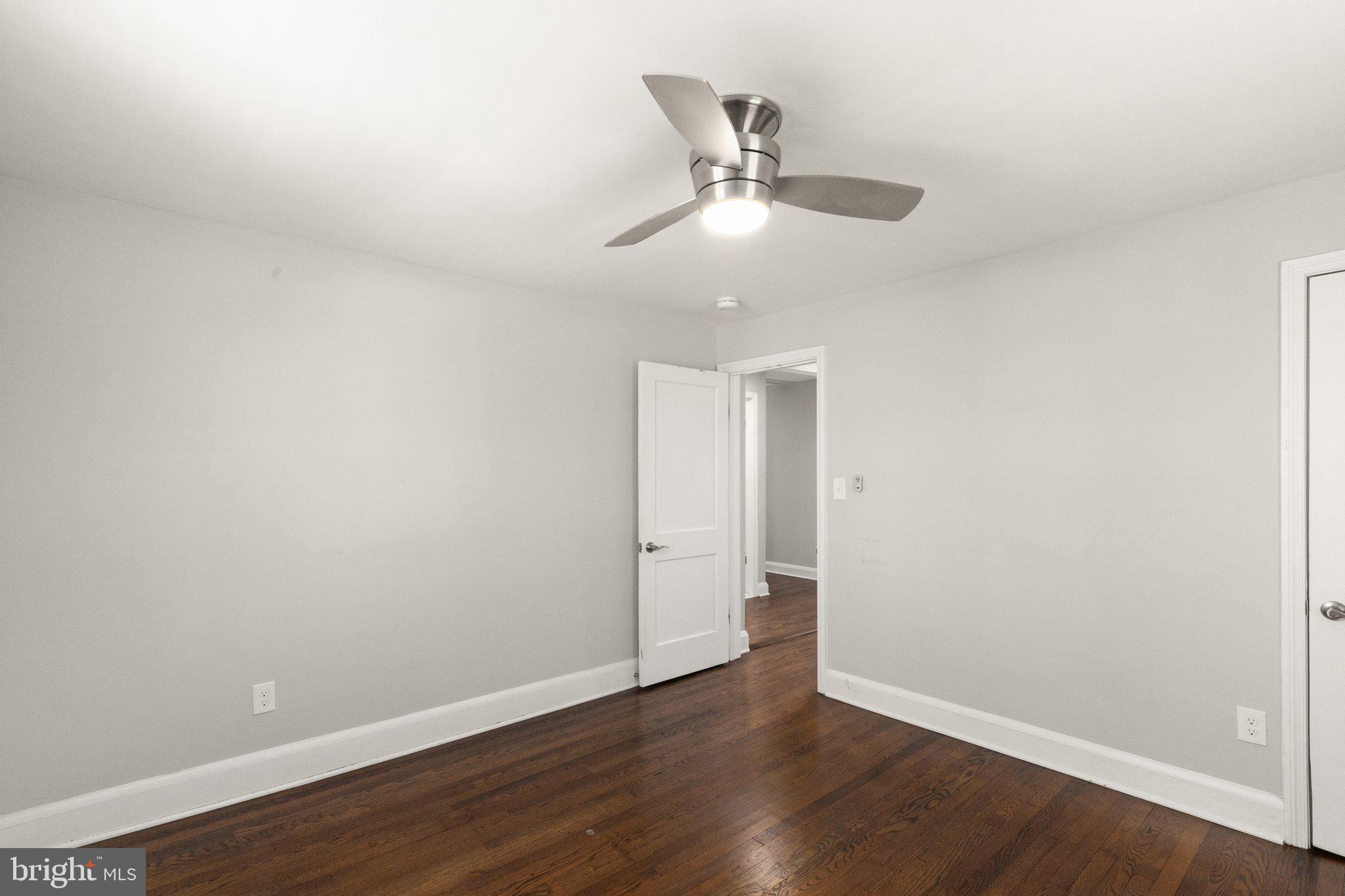 7512 Brightside Avenue Baltimore, MD 21237 - Photo 15 of 32 an empty room with wooden floor fan and windows