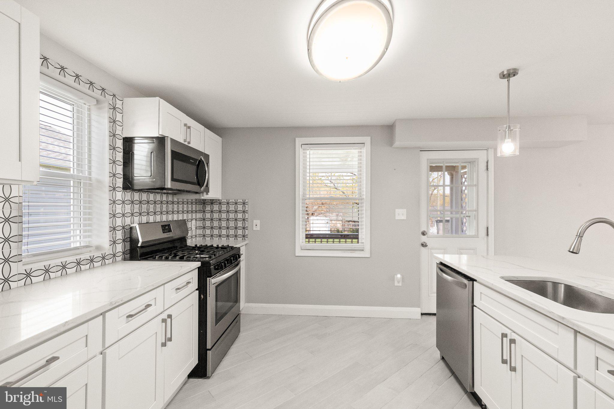 7512 Brightside Avenue Baltimore, MD 21237 - Photo 8 of 32 a kitchen with granite countertop a sink a stove and cabinets