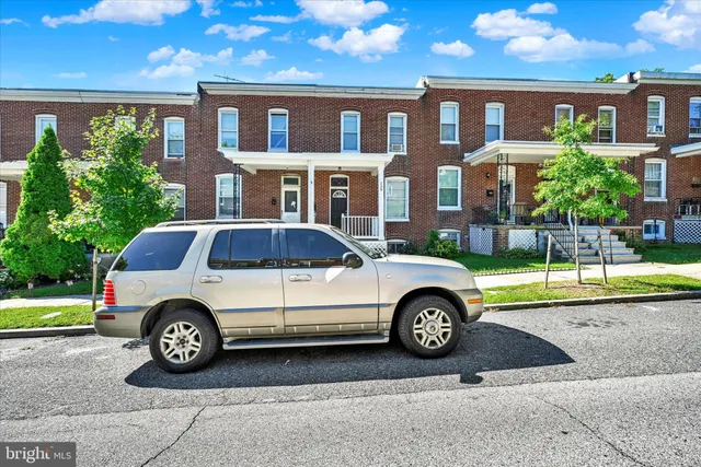 a car parked in front of a brick house