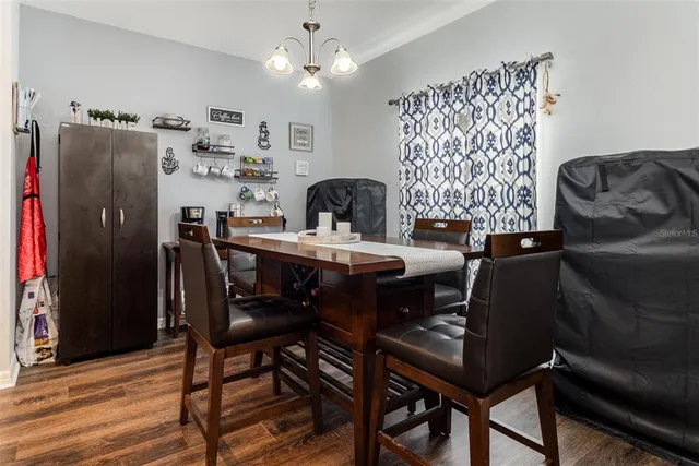 a kitchen with a refrigerator a microwave a sink and chairs