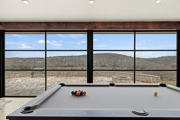 a dining room with furniture large windows and wooden floor