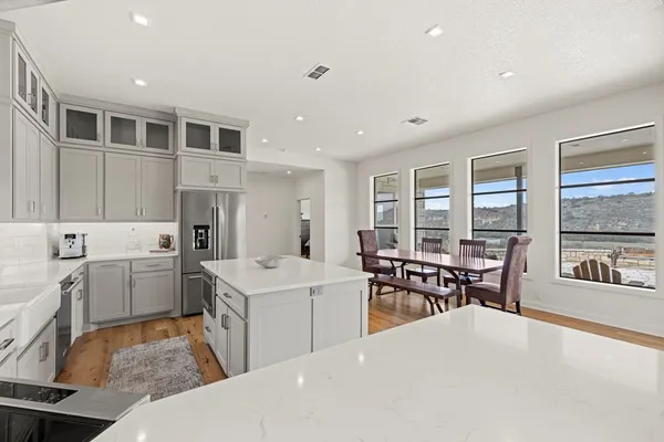 a kitchen with granite countertop white cabinets and white appliances