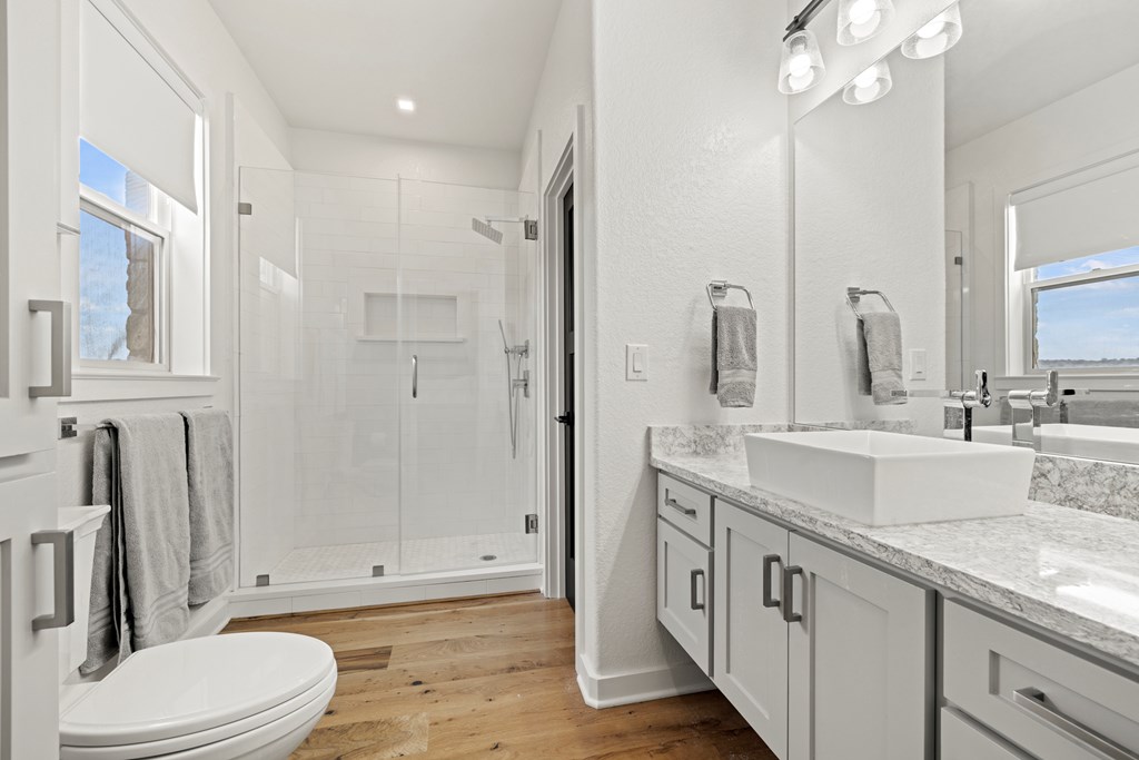 256 Persimmon Point Mason, TX 76856 - Photo 26 of 60 a bathroom with a granite countertop sink a toilet a mirror and shower