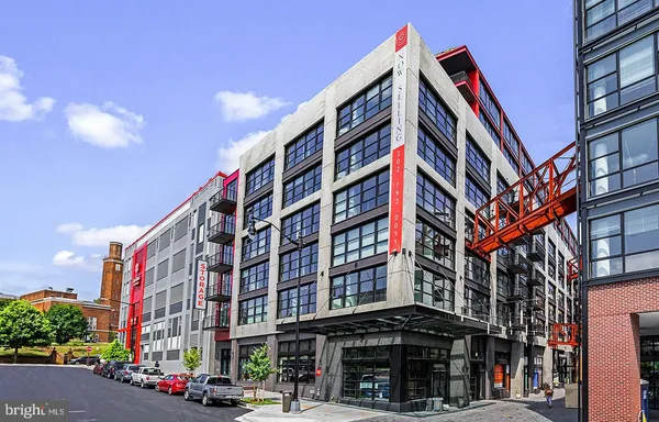a front view of multi story residential apartment building with retail shops