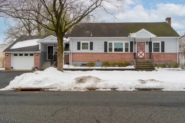 a front view of a house with a yard covered in snow